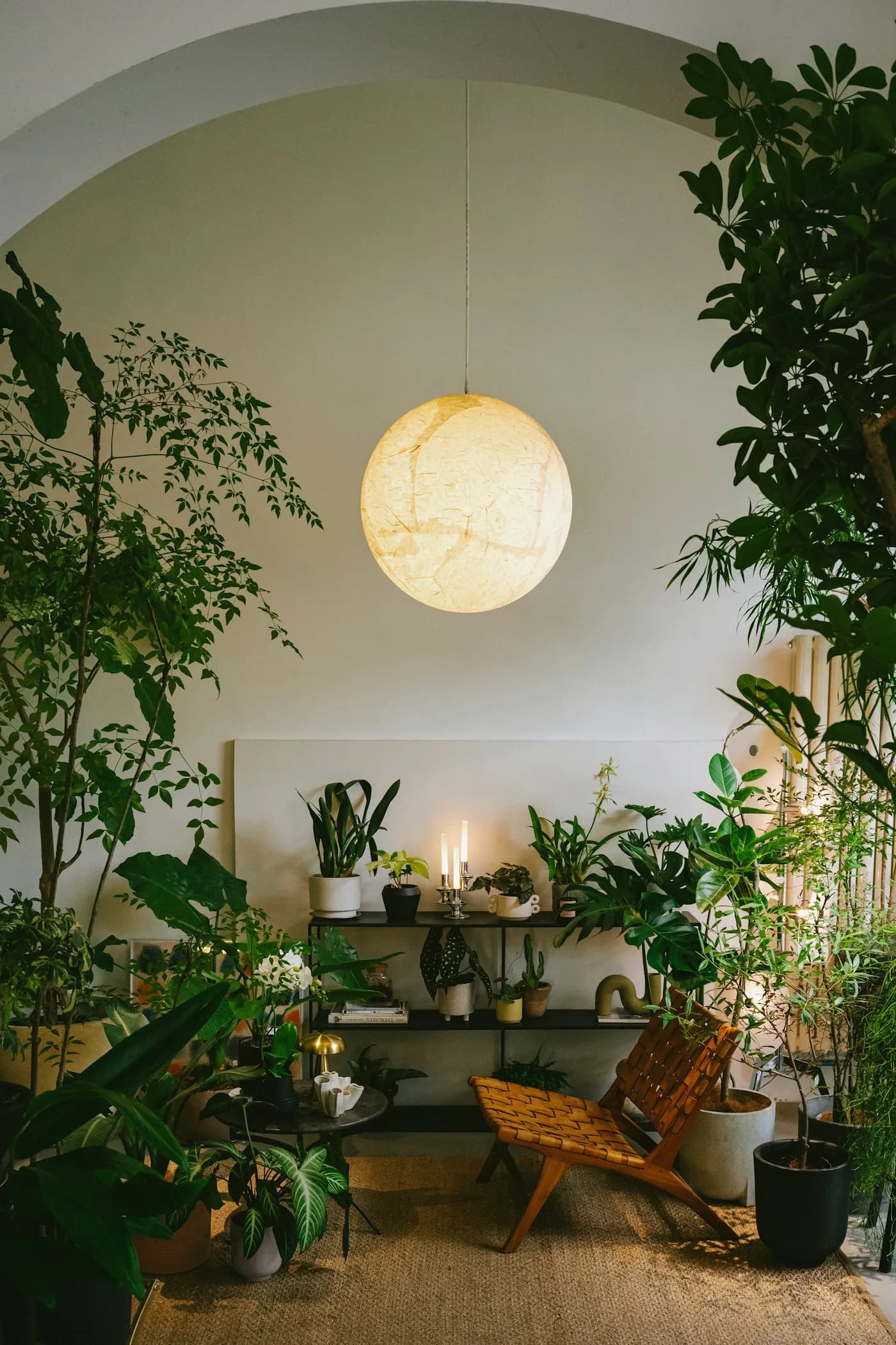 A relaxing corner with an armchair, warm light and indoor plants